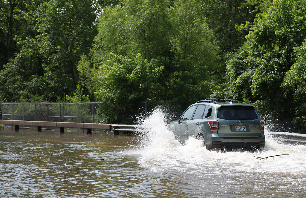 A car drives through floodwaters on Chapel Hill Road